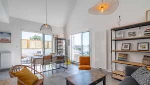 A spacious living area with a dining table, chairs, a sofa, and a bookshelf. - Le Clos Moguer by Interhome (Quiberon)