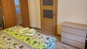 Ein Schlafzimmer mit einem Bett, einem Kleiderschrank und einer Tür.