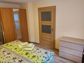Une chambre à coucher avec un lit, une armoire et une porte.
