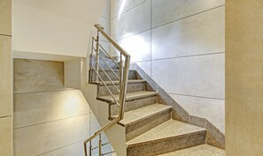 Una escalera moderna con escalones de granito y barandillas de acero inoxidable.