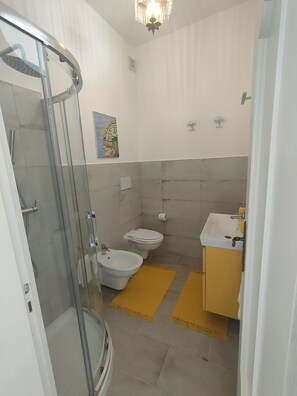 Ein Badezimmer mit Duschkabine, Toilette und Waschbecken.