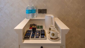 A minibar setup with a selection of beverages, a coffee machine, and a small shelf with decorative flowers. - A Residence - A Member of The Luxury Stay Group (Kota Kinabalu)