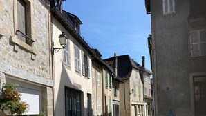 A narrow street lined with traditional buildings, featuring stone facades and shuttered windows. - Large, bright apartment (Argentat-sur-Dordogne)