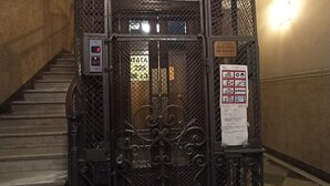 Un ascensor metálico con un panel de control y un cartel en la puerta.