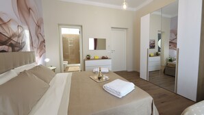 Una habitación de hotel con una cama grande, una mesita de noche con lámpara, un espejo y un armario.