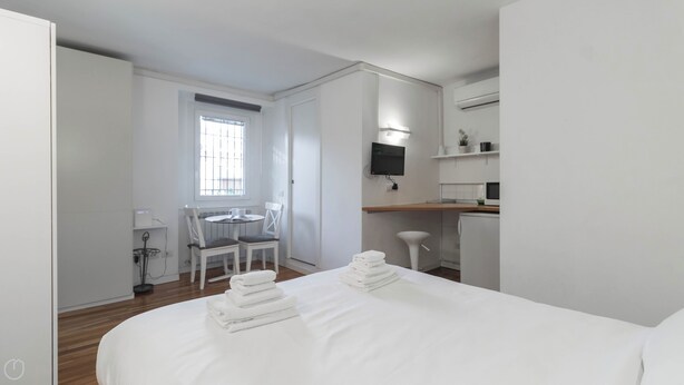 A hotel room with a bed, a small table with chairs, a TV, and a kitchenette. - Italianway - Moscova 52 A (Milan)
