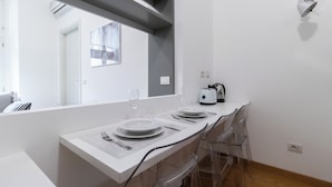 A modern kitchen with a white countertop, a toaster, and a kettle. - Italianway Easy - Sarpi 10 A (Milan)