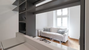 A modern living room with a white sofa, a coffee table, and a bookshelf. - Italianway Easy - Sarpi 10 A (Milan)