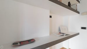 Une pièce moderne et minimaliste, avec un intérieur épuré et aux couleurs claires. On y trouve un bureau sur lequel sont posés un magazine et un smartphone.