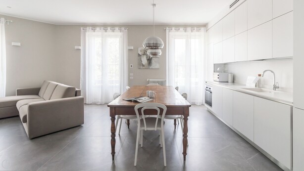 A modern kitchen with white cabinets, a wooden dining table, and a built-in oven. - Italianway Comfort - Vincenzo Monti 29 A (Milan)