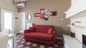 A modern living room with a red sofa, a round mirror, and abstract wall art. - Italianway Comfort - Borsieri 11 B (Milan)