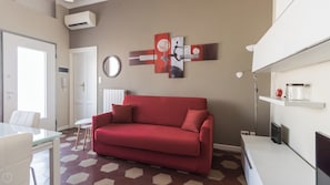 A modern living room with a red sofa, a round mirror, and abstract wall art. - Italianway Comfort - Borsieri 11 B (Milan)