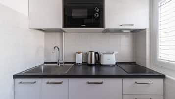 Apartamento (1 Bedroom) | Cocina privada | Microondas, placa de cocina, trona infantil y utensilios de cocina