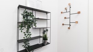A black metal shelf unit with multiple compartments, some containing plants. - Italianway - Jacopo dal Verme 4 (Milan)