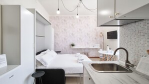 A compact hotel room with a bed, bedside table, and a built-in sink. - Italianway - Gallura 9 (Milan)