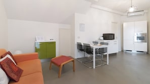 A compact living space with a kitchenette, a dining area, and a seating area. - Italianway Easy - Plinio 64 (Milan)
