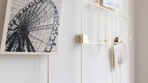 A wall with a black and white photograph of a Ferris wheel, a white door with a gold handle, and a white wall with a small window. - Italianway Easy - Plinio 64 (Milan)