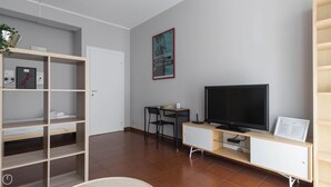 A modern living room with a TV, a desk, and a bookshelf. - Italianway Easy - Sanfelice 10 (Milan)