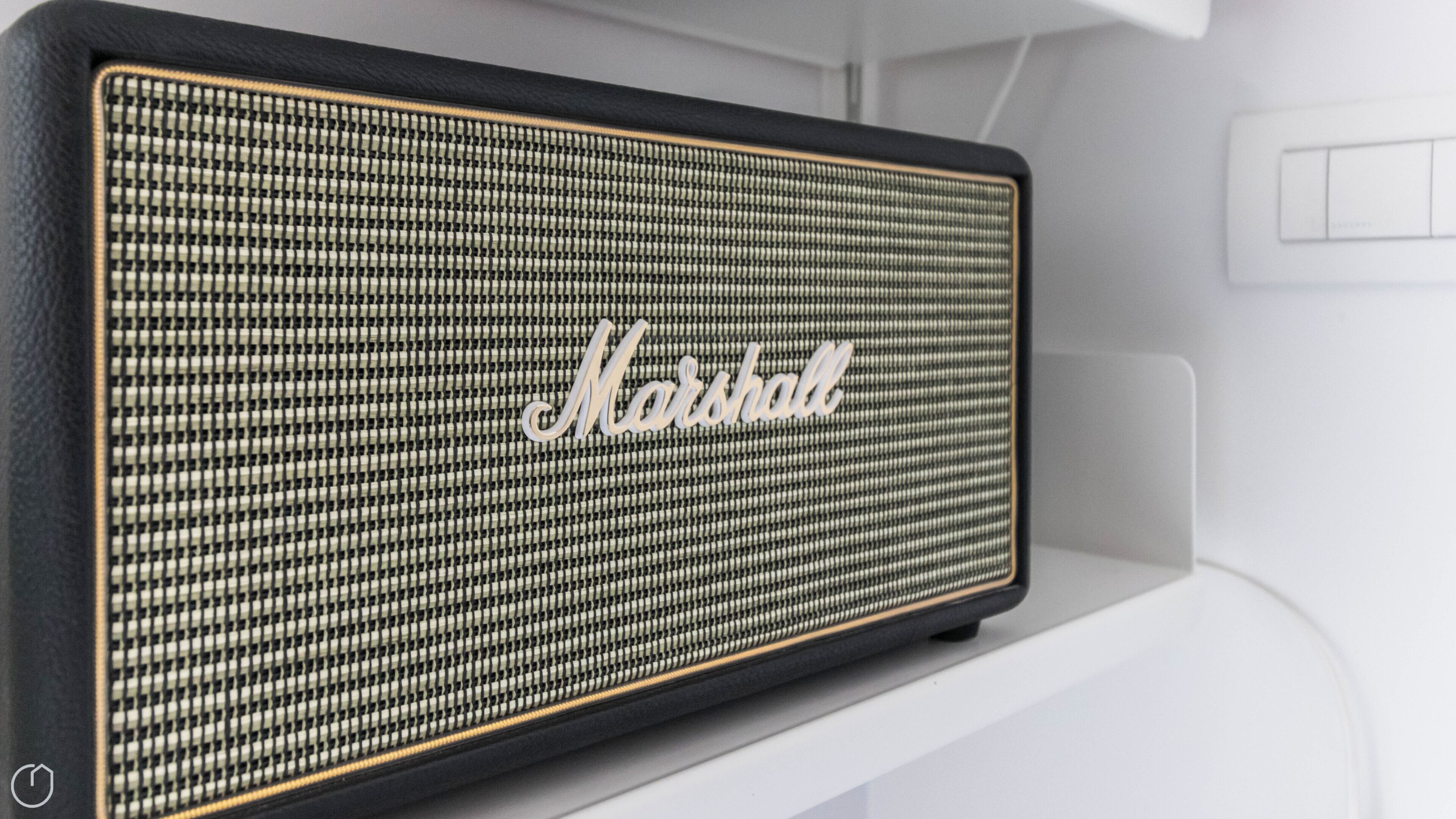 A Marshall speaker with a black and white grille, mounted on a white shelf.