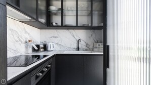 Une cuisine moderne avec des plans de travail en marbre, un robinet noir et une machine à café.
