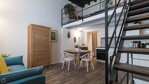 Ein gemütlicher Wohnbereich mit Essplatz, einer Couch, einer Treppe und einer Küche.