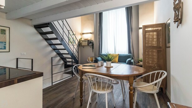 Ein moderner Wohnbereich mit Essplatz, einer Treppe und Blick ins Freie.