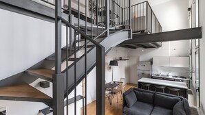 A modern interior with a spiral staircase, a dining area, and a kitchen. - Italianway - Salomone 51 (Milan)