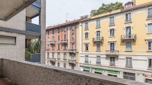 A row of multi-story buildings with balconies, a restaurant, and a pizza place. - Italianway - Spontini 10 (Milan)