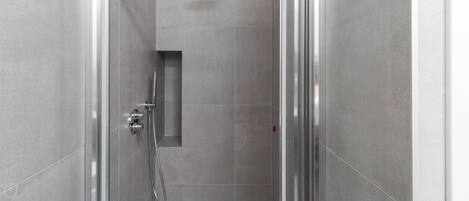 A modern shower with a handheld showerhead and a wall-mounted control panel.