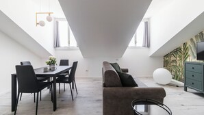 A modern loft apartment with a dining area, a sofa, and a TV on a green cabinet. - Italianway - Commenda 35 C (Milan)