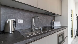 A modern kitchen with a stainless steel sink, a kettle, and a paper towel dispenser. - Italianway - Commenda 35 C (Milan)