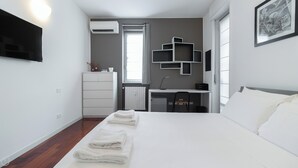 Quarto moderno com cama, escrivaninha e radiador.