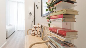 A cozy reading nook with a chair, a small table, and a stack of books. - Italianway - Dei Transiti 7 (Milan)