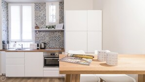 A modern kitchen with white cabinetry, a wooden countertop, a built-in oven, and a window with patterned tiles. - Italianway - Dei Transiti 7 (Milan)