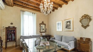 A living room with a glass table, a sofa, a chandelier, and framed pictures on the wall. - Italianway Easy - Ripa Ticinese 53 B (Milan)