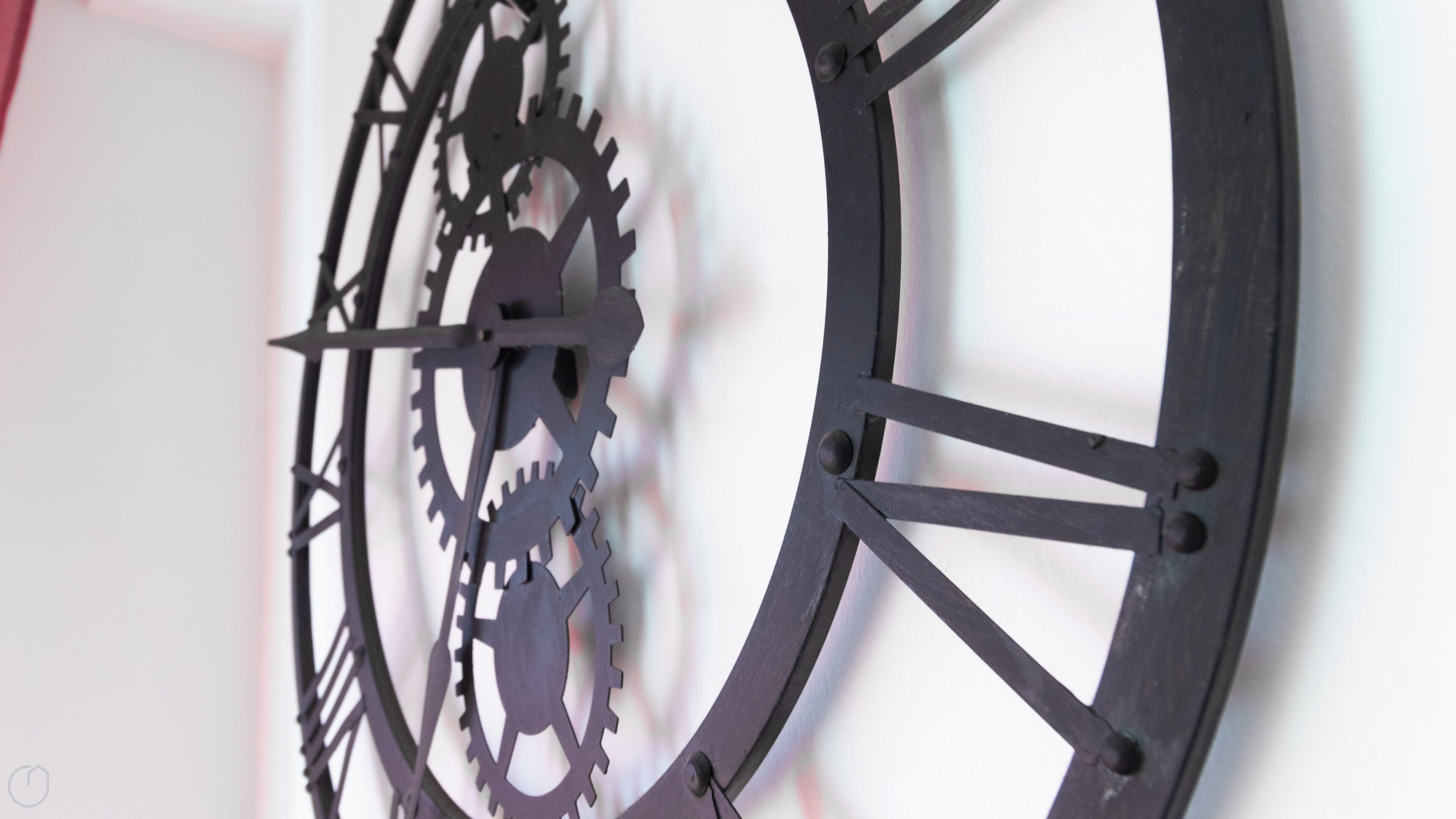 A wall-mounted clock with interlocking gears.