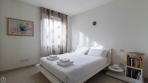 A modern bedroom with a bed, a bedside table, a bookshelf, and a painting on the wall. - Italianway Easy - Dall'ongaro 24 (Milan)