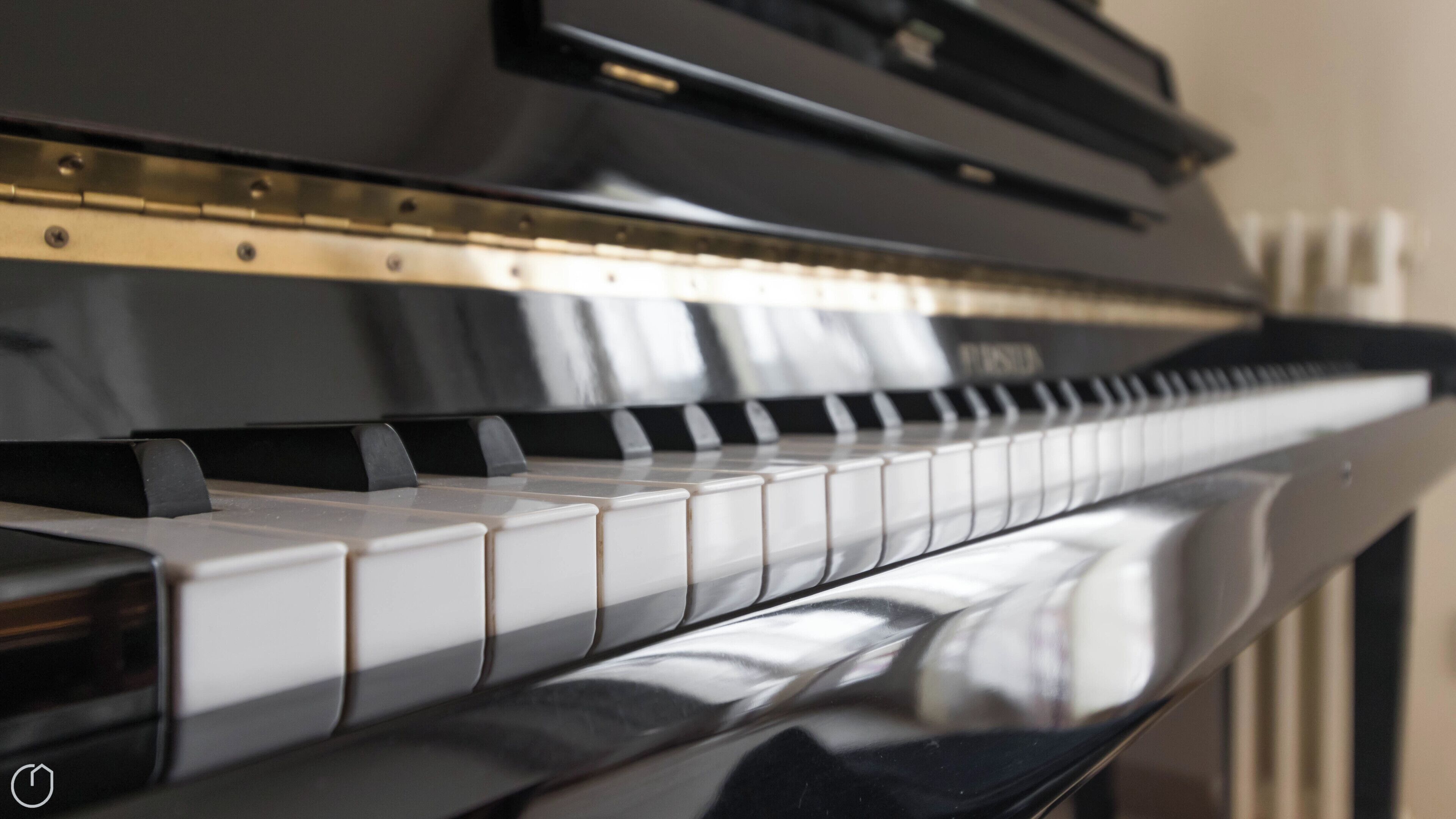 A close-up of a piano keyboard with a reflective surface.