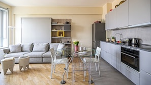 Une cuisine moderne avec une table à manger en verre, un canapé et une table basse.