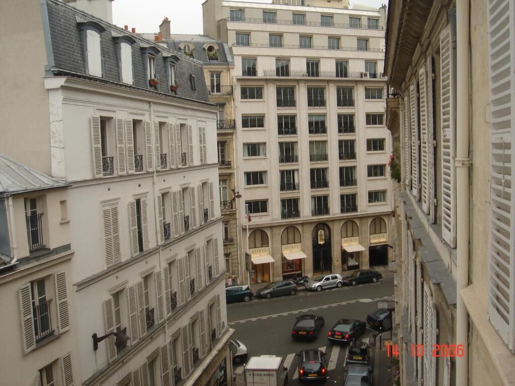 Une vue de rue avec des bâtiments, des voitures et un horodatage.