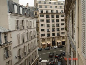 Une vue de rue avec des bâtiments, des voitures et un horodatage.