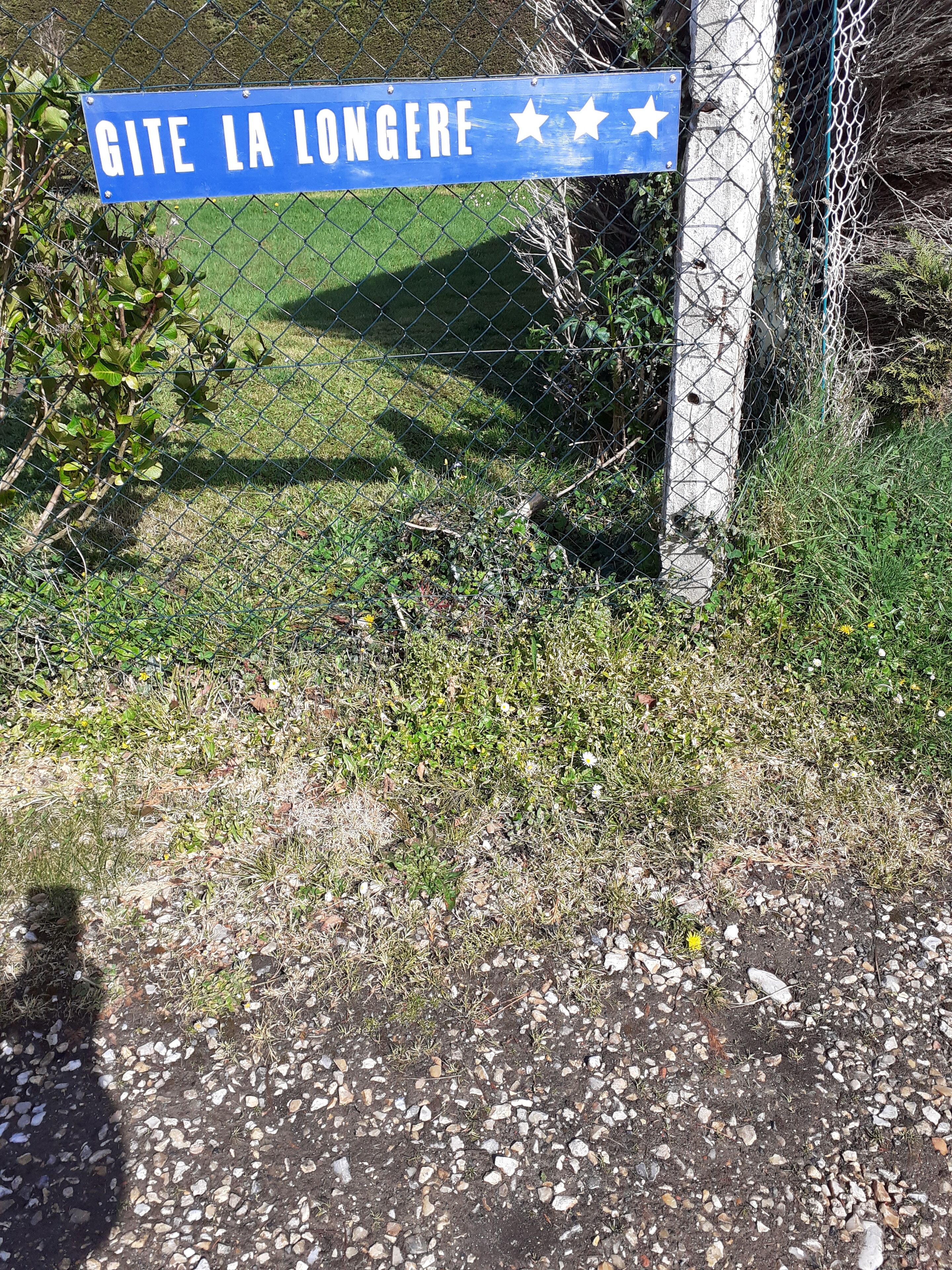 A blue sign with white text reading "GITE LA LONGERE" and three white stars.