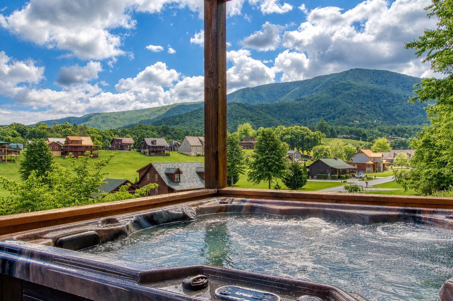 A hot tub with a view of a mountain and houses.