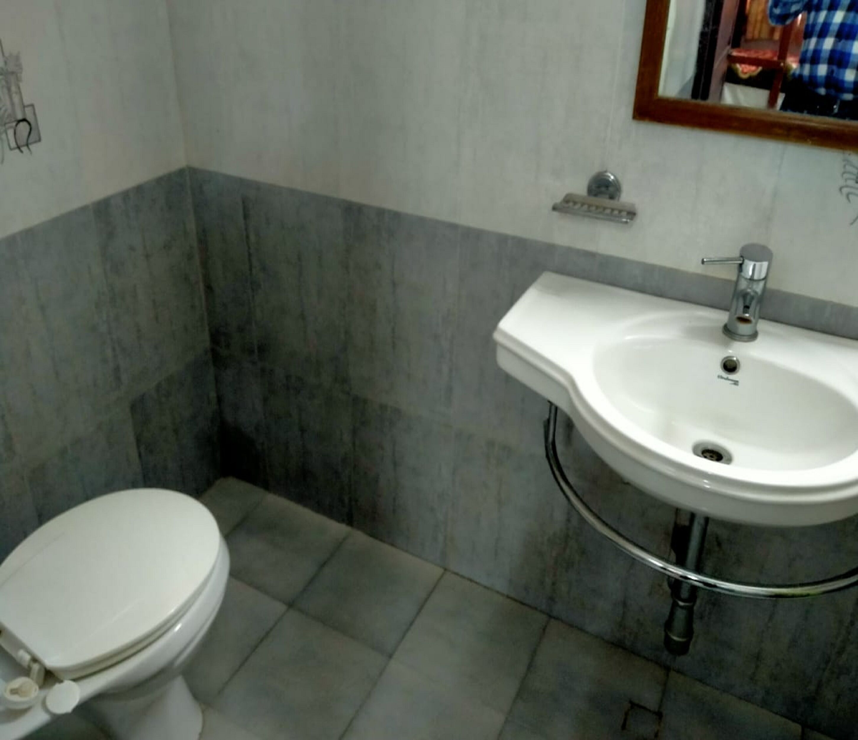 Ein Badezimmer mit Toilette, Waschbecken und Spiegel.