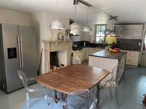 Kitchen features a central island with a countertop, stainless steel appliances, and ample storage.