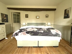 Cozy retreat with a large bed, floral-patterned bedspread, and a dresser with drawers.