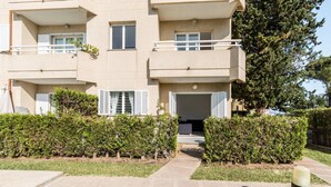 A multi-story residential building with balconies, a paved entrance, and well-maintained hedges. - 2 Bedroom Duplex Apartment in Puerto Pollensa (Puerto Pollensa)
