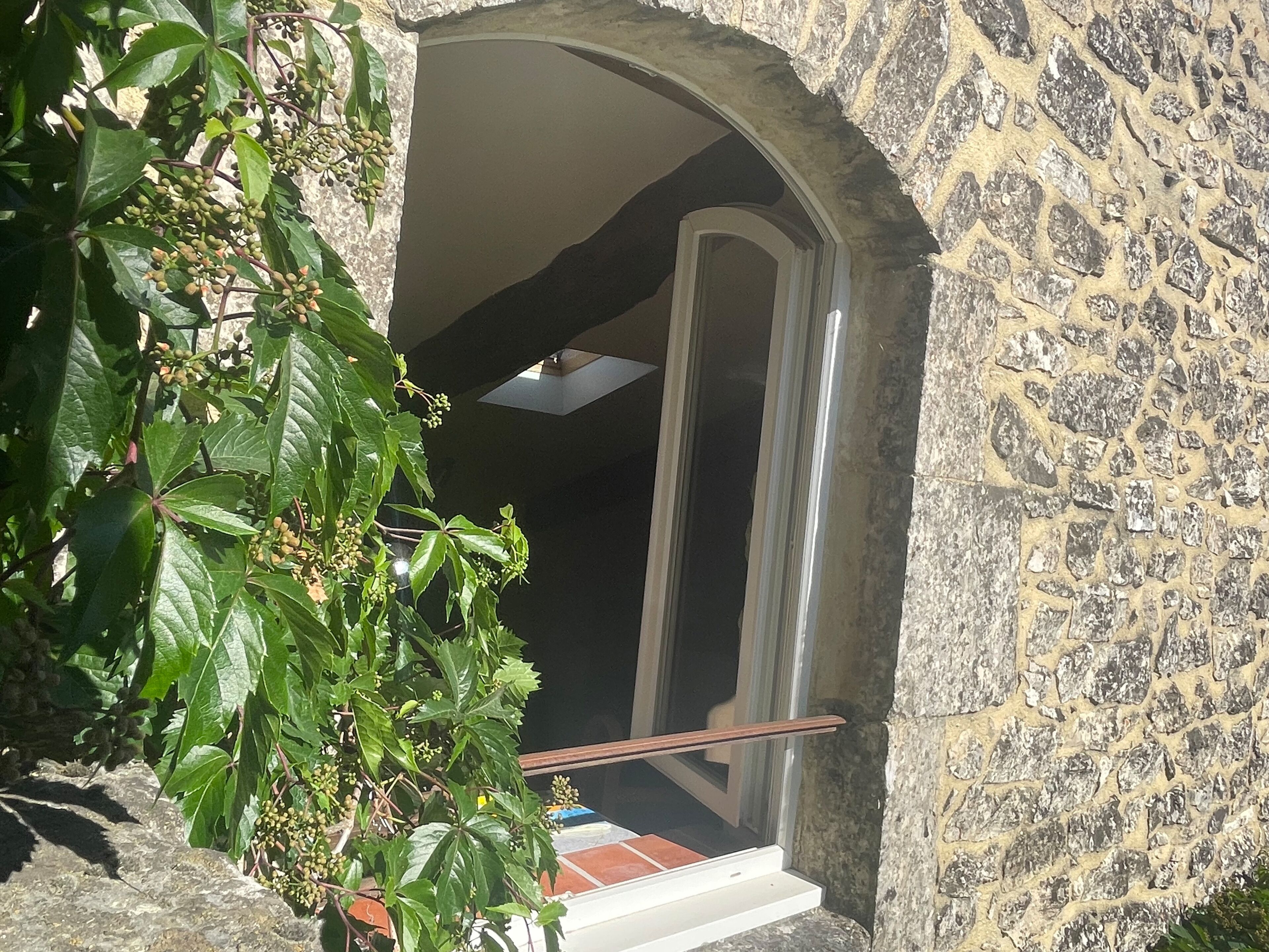 An arched doorway leading into a building with a stone exterior.