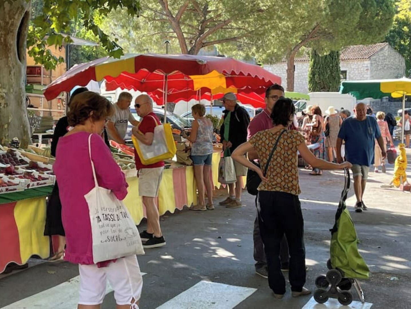 An outdoor market with various stalls and people browsing.