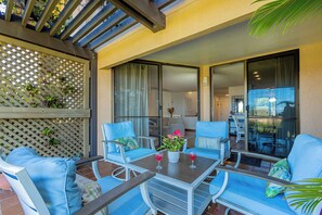 Eine Terrasse mit blauen Stühlen und einem Tisch, ein Holzzimmer und ein Blick ins Haus.